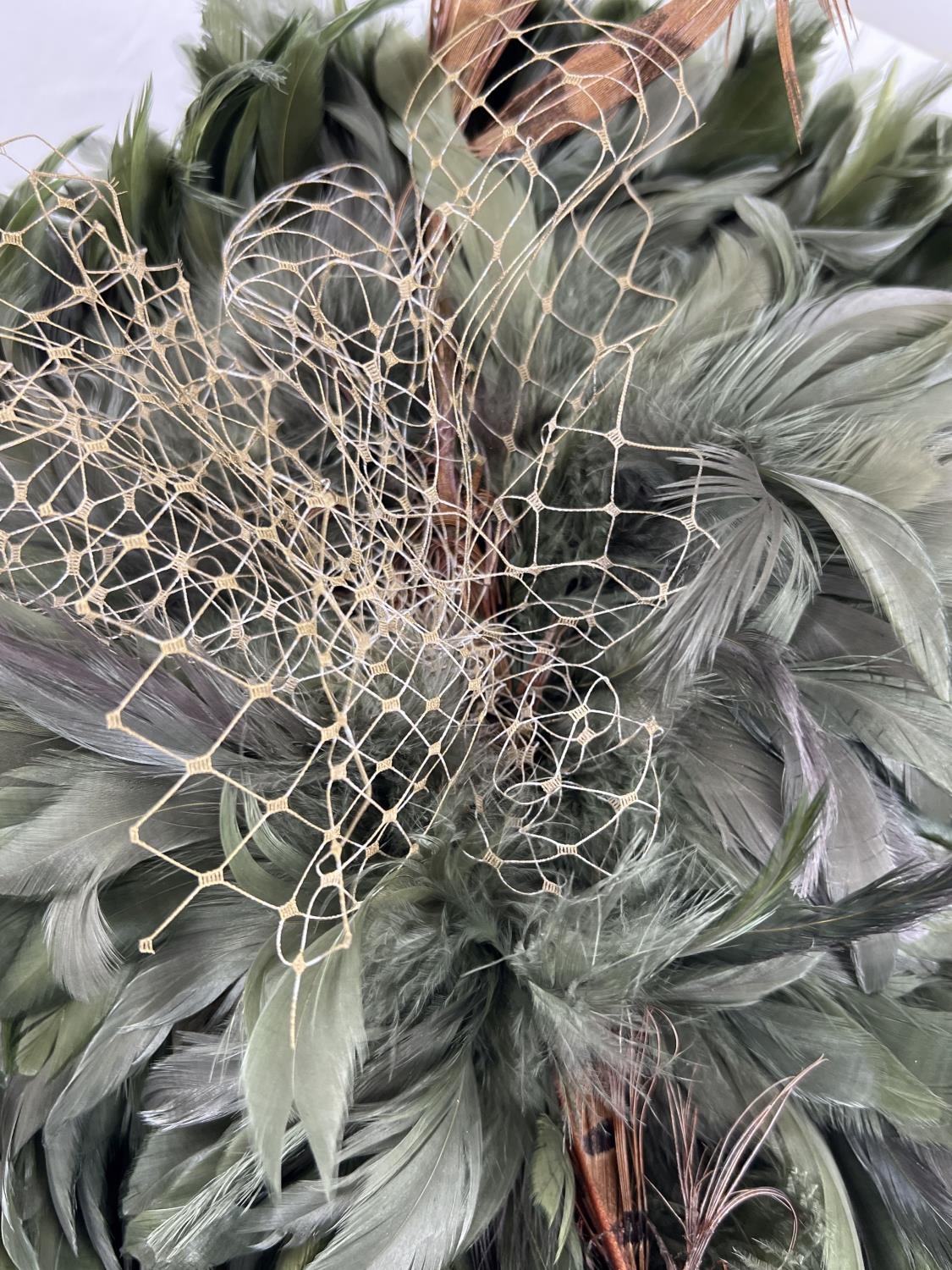 A green feather fascinator style hat with pheasant feather and net detail. Together with a Harvey - Image 3 of 4