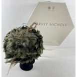 A green feather fascinator style hat with pheasant feather and net detail. Together with a Harvey