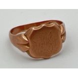 A vintage 9ct rose gold men's signet ring with shield shaped cartouche. Worn engraved monogram to