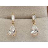 A pair of 14ct gold drop style earrings set with baguette cut and teardrop cut cubic zirconia