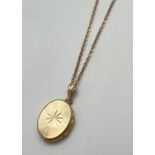 A 9ct gold back & front oval shaped locket with engraved sunburst design to front. On a 17" rolo