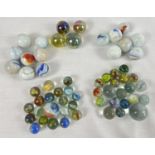 A collection of vintage marbles in varying sizes and colours to include milky glass, swirl