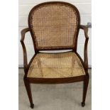 An Edwardian mahogany arm chair with re-caned seat and shaped back. With shaped arms and tapered