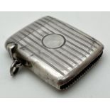 An art Deco silver vesta case with engine turned decoration and circular empty cartouche to front.