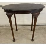 An Edwardian dark wood oval topped occasional table with straight legs, bun feet and shaped top.