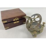 A brass sextant compass in a brass banded wooden box.