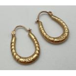 A pair of 9ct gold hoop style earrings with floral decoration. Posts marked 375. Total weight