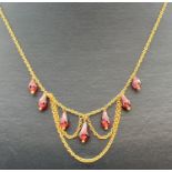 A 9ct gold 18" decorative belcher chain necklace with 7 teardrop cut garnets stone pendants.