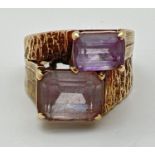 A vintage 9ct gold 2 stone dress ring with textured design to shoulders. Set with baguette cut