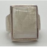 A modern design silver dress ring set with a large square cut moonstone. Silver marks to inside of