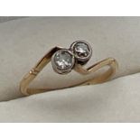 An Art Deco 2 stone diamond dress ring in a twist design setting. 2 round cut bezel set .10ct