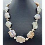 An 18" alternating large square shaped baroque pearl and round cultured pearl necklace. In white,