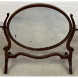 An Edwardian oval dressing table swing mirror with shaped legs and supports. Approx. 48.5 x 51.5cm.