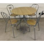 A modern circular wood effect and silver painted metal dining table with 4 matching chairs. Table