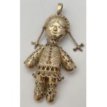 A large vintage silver gilt articulated pendant in the from of a rag doll. Set with small garnets