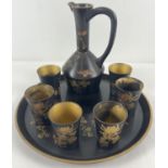 An Oriental style black lacquer sake/liqueur set with gilt and chrysanthemum decoration. Comprising: