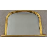 A large curved top gilt framed over mantel mirror with plinth base. Approx. 77 x 118cm.