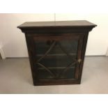 An antique dark oak, glass fronted wall cabinet with decorative carved panel sides. 2 adjustable