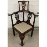 An Edwardian Chippendale style high back corner chair with carved detail. Decoratively shaped