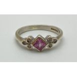 A 9ct gold pink sapphire and diamond dress ring. Central bezel set square cut pink sapphire with 3