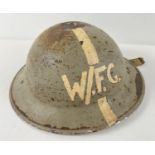 A British WWII MkII Home Front steel helmet, stamped 1941. Painted grey with longitudinal white