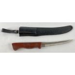 A wooden handled 5.5 inch blade survival knife with hard plastic sheath and carry loop.