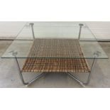 A large modern metal framed coffee table with glass top and basket weave undershelf. Approx. 46cm