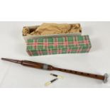 A boxed vintage wooden practice bagpipe chanter with two reeds.