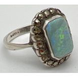 A vintage style silver dress ring set with an emerald cut opal, surrounded by marcasite stones.