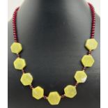 A 17" Peridot and garnet beaded necklace with gold tone S hook clasp. Made from small spherical