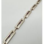 A modern design rectangular shaped 5 panel bracelet, each set with a small round cut amethyst.
