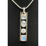 A modern design silver pendant set with 4 varying cut moonstones. On an 18" fine snake chain with