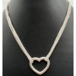 A modern design multi strand heart pendant necklace with extension chain and lobster style clasp.