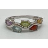 A silver wave design multi gem set half eternity ring. Set with 5 oval cut semi precious stones -