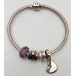 A pale lilac leather and silver charm bracelet with 4 charms, by Chamila. Charms comprise: purple