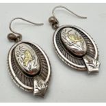 A pair of antique white metal drop style earrings with engraved bird decoration. Approx. 3.25cm long