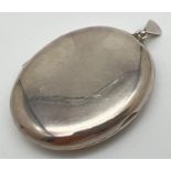 A large silver oval shaped locket with shaped hanging bale. Hallmarked to reverse for Birmingham