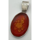 A vintage silver and amber oval pendant with carved rose decoration to the amber. Marked 925,