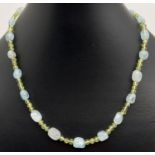 An aquamarine and peridot 16" beaded necklace with white metal T bar clasp. Made from small