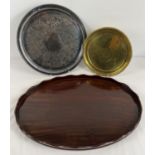 3 vintage serving trays. An oval shaped mahogany tray with scalloped edge (55.5cm long), a silver