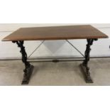 A vintage dark wood topped table with cast iron base. Painted black cast iron legs with floral,