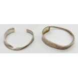 2 modern design cuff style bangles, one with hammered finish. Silver marks to inside of both.
