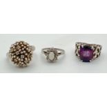 3 vintage silver dress rings. A contemporary design flower head set with small clear stones. A
