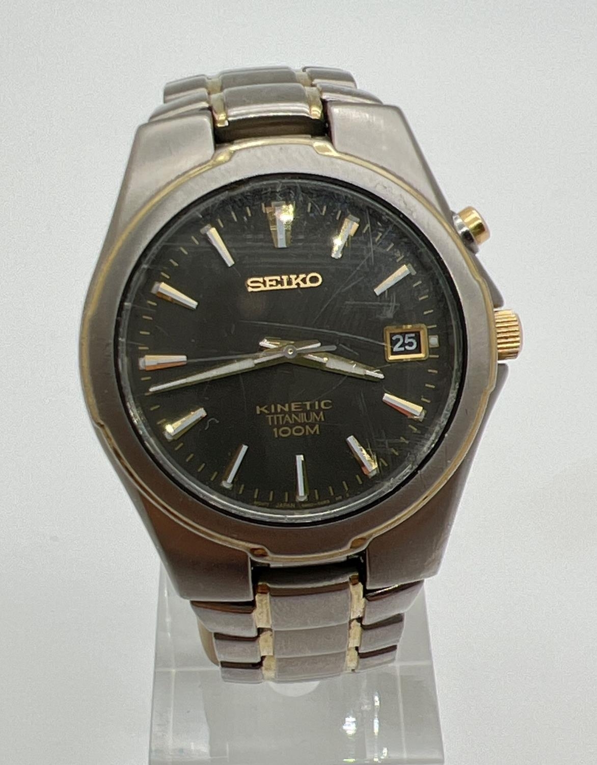 A Seiko 5M62-OAMO kinetic Titanium wristwatch with black face and gold tone hands. Hour markers with