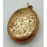 A Victorian gold tri-fold locket with floral decoration to front and back. Engraved monogram to