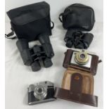 2 vintage pairs of binoculars together with 2 cameras. Binoculars - a pair of Tasco Zip 8 x 30mm