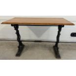 A vintage wooden topped table with cast iron base. Painted black cast iron legs with scroll,