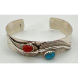 An Native American style cuff bangle with feather style decoration and natural stones. Inside marked