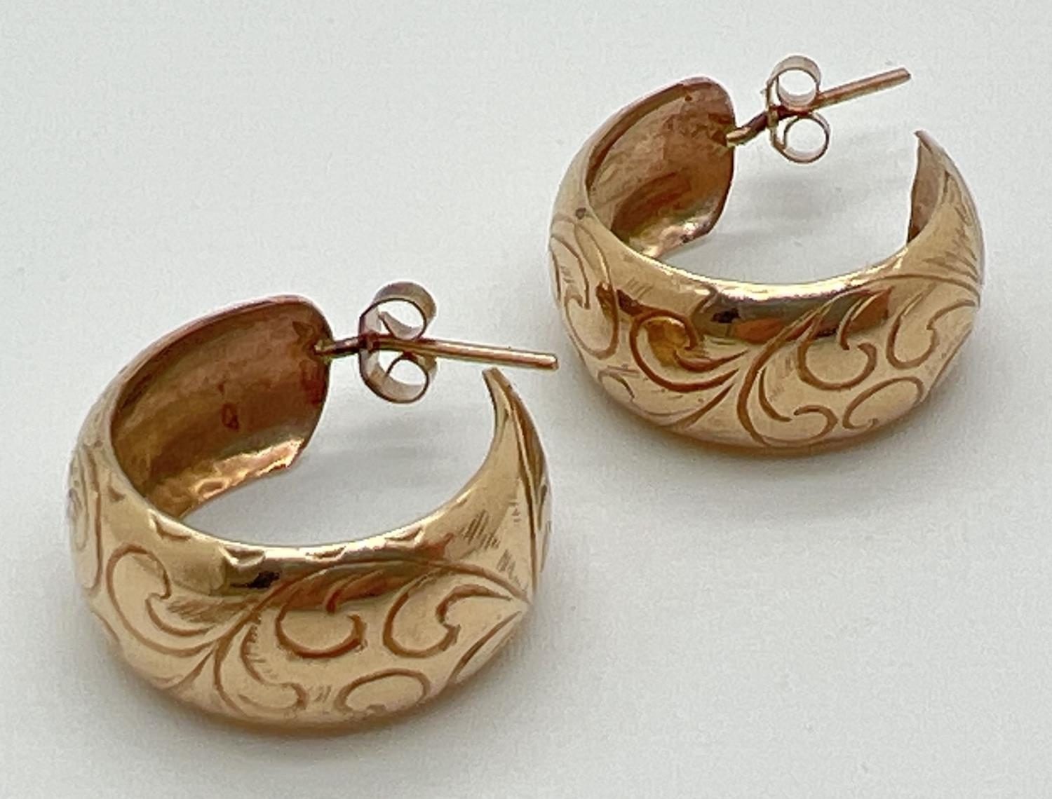 A pair of vintage 9ct gold half hoop earrings with engraved floral decoration. Complete with