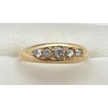 An Edwardian 18ct gold and diamond engagement ring. Band style set with 5 graduating size round